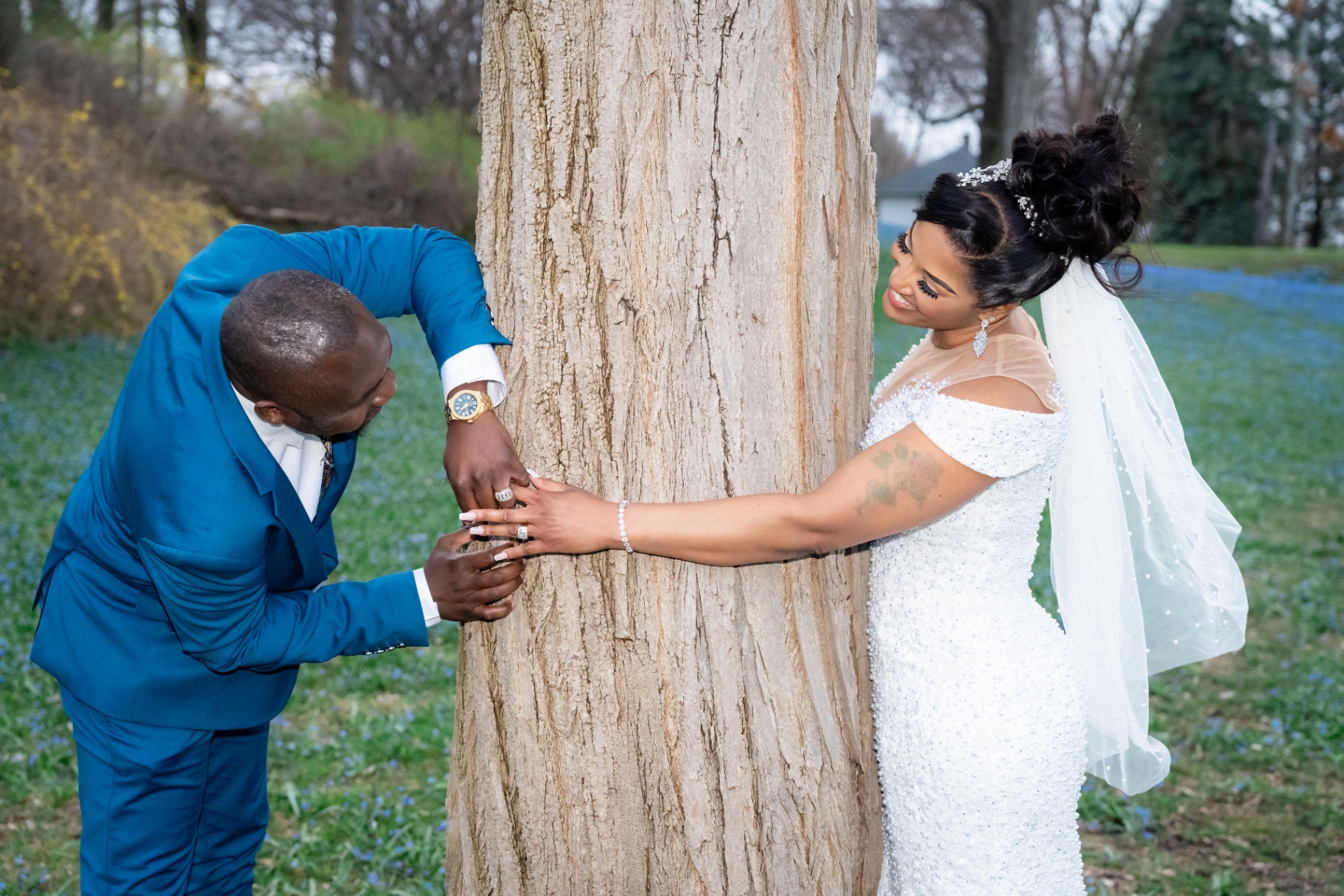 Bride and groom sharing a first look by a tree