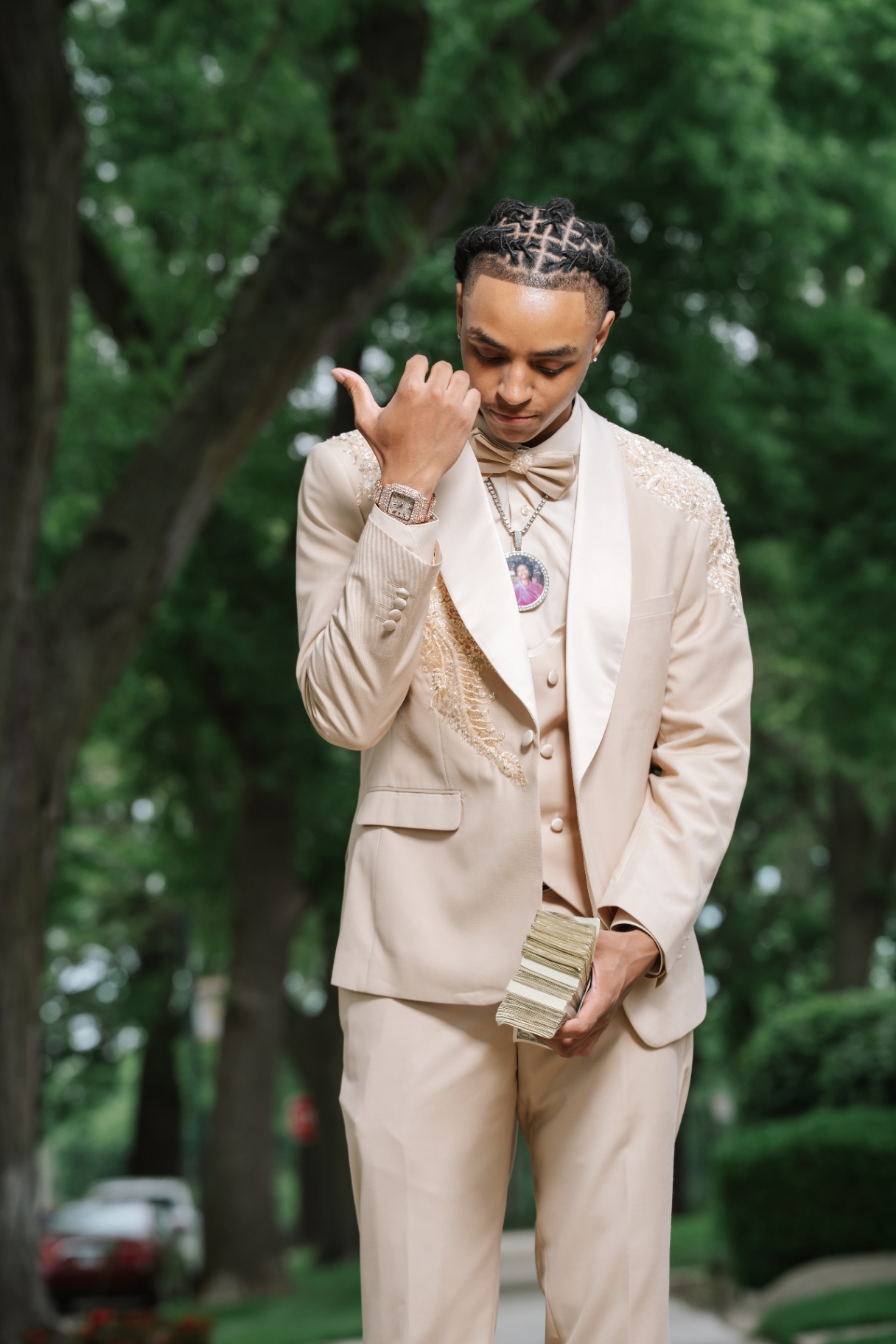Prom portrait in cream suit beneath trees